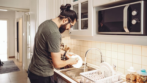 man_washing_dishes_in_kitchen_sink-1153674131 (1)